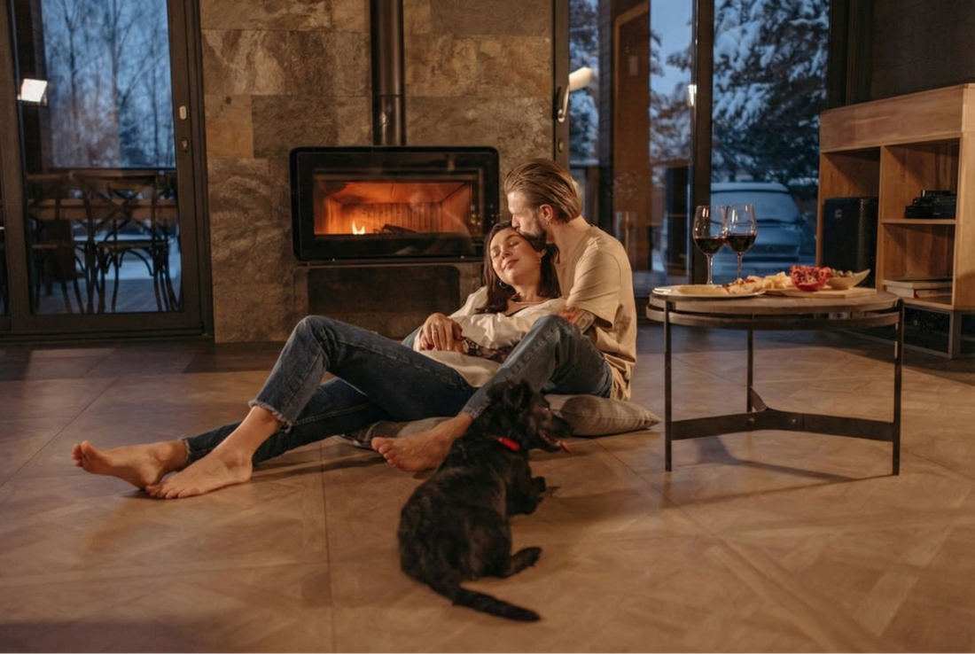  A cozy winter scene with glasses of red wine beside a warm fireplace and a dog curled up nearby
